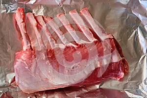 Uncooked rack of lamb on aluminium / aluminum cooking foil