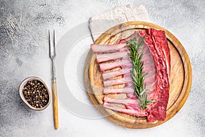 Uncooked rack of lamb, raw mutton chops on wooden board. grey background. top view