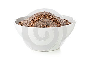 Uncooked, raw linseed or flax seed in white bowl over white back