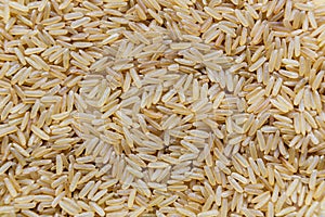 Uncooked raw long brown rice grains background, top view