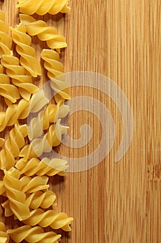 Uncooked raw pasta background on wooden background