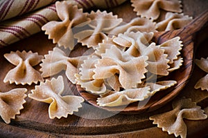 Uncooked or raw wholemeal farfalle pasta closeup