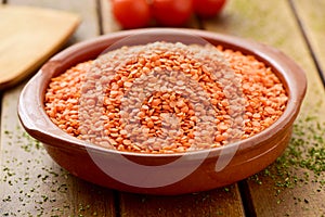 Uncooked red lentils in an earthenware bowl