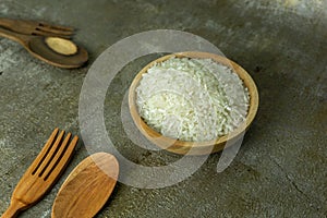 uncooked rice or dry rice. raw rice in wooden bowl with wooden spoon and fork