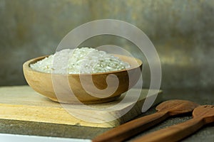 uncooked rice or dry rice. raw rice in wooden bowl with wooden spoon and fork