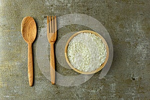 uncooked rice or dry rice. raw rice in wooden bowl with wooden spoon and fork