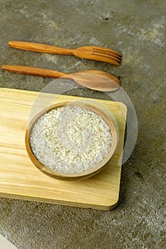 uncooked rice or dry rice. raw rice in wooden bowl with wooden spoon and fork