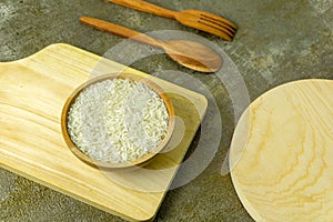uncooked rice or dry rice. raw rice in wooden bowl with wooden spoon and fork