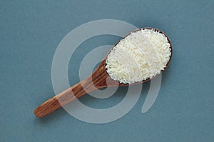 Uncooked rice, jasmine rice, mali rice,Thai jasmine rice in a wood ladle on white background