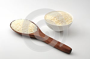 Uncooked rice, jasmine rice, mali rice,Thai jasmine rice in a wood ladle,white bowl ceramic on white background