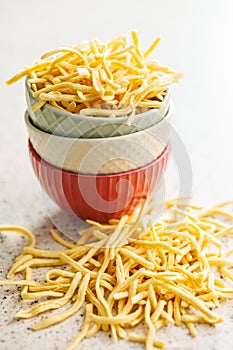 Uncooked spaetzle pasta in bowl on kitchen table