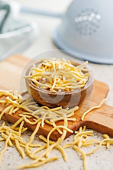 Uncooked spaetzle pasta in bowl on kitchen table