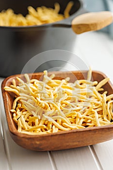 Uncooked spaetzle pasta in bowl on kitchen table