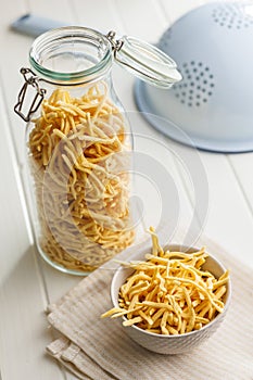 Uncooked spaetzle pasta in jar on kitchen table