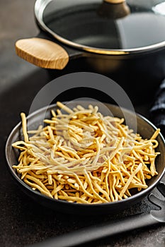 Uncooked spaetzle pasta on plate on kitchen table