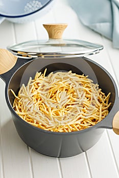 Uncooked spaetzle pasta in pot on kitchen table