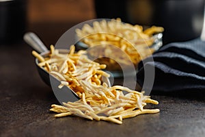 Uncooked spaetzle pasta in scoop on kitchen table