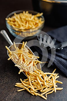 Uncooked spaetzle pasta in scoop on kitchen table