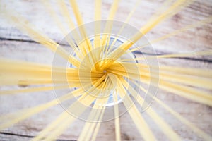 Uncooked spaghetti pasta isolated on vintage wooden table