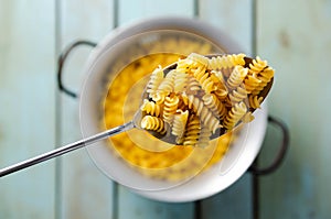 Uncooked spiral pasta in a spoon.