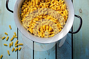 Uncooked spiral pasta in a strainer.