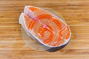 Uncooked steak of arctic char on the wooden cutting board