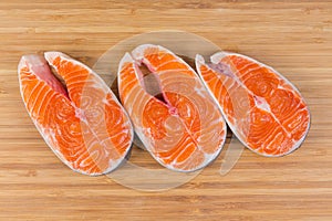 Uncooked steaks of arctic char on the wooden cutting board