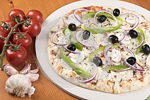 Uncooked vegetarian pizza with olives, peppers, onion, mushrooms and garlic