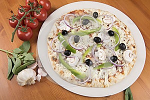 Uncooked vegetarian pizza with olives, peppers, onion, mushrooms and garlic