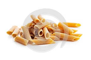 Uncooked whole grain pasta isolated on white background. Raw penne pasta