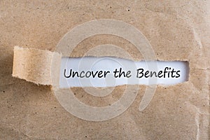 Uncover The Benefits text on brown envelope. Word Uncover The Benefits on torn paper. Concept Image.