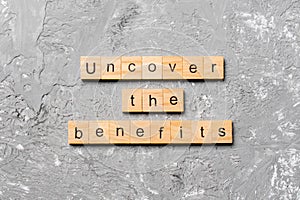 Uncover the benefits word written on wood block. uncover the benefits text on table, concept