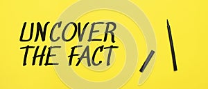 UNCOVER THE FACT sign with black marker on a yellow background. With copy space ready for your text