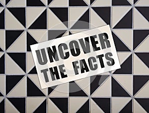 Uncover the Facts card on wooden background. Social concept. Business concept