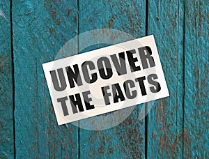 Uncover the Facts card on wooden background. Social concept. Business concept