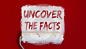 Uncover the Facts .One open can of paint with white brush on it on red background. Top view