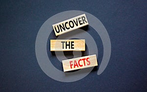 Uncover the facts symbol. Concept words Uncover the facts on wooden blocks on a beautiful black table black background. Business