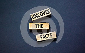 Uncover the facts symbol. Concept words Uncover the facts on wooden blocks on a beautiful black table black background. Business