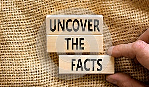 Uncover the facts symbol. Concept words Uncover the facts on wooden blocks on a beautiful canvas table canvas background.