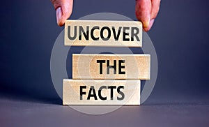 Uncover the facts symbol. Concept words Uncover the facts on wooden blocks on a beautiful grey table grey background. Businessman