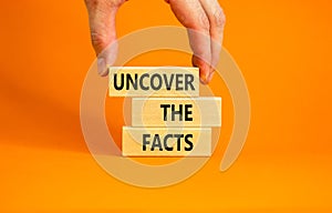 Uncover the facts symbol. Concept words Uncover the facts on wooden blocks on a beautiful orange table orange background.