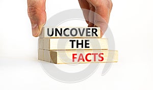 Uncover the facts symbol. Concept words Uncover the facts on wooden blocks on a beautiful white table white background.
