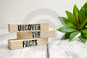 Uncover the facts symbol. Concept words Uncover the facts on wooden blocks on a beautiful white table white background