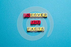 Uncover the facts - word concept on cubes, text