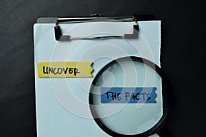 Uncover - The Facts write on sticky notes isolated on office desk