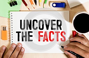 UNCOVER THE FACTS written on white page. Business