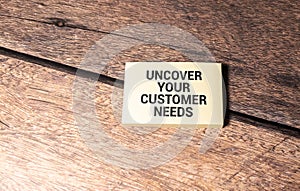 uncover your customer needs text on white notepad