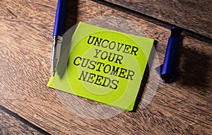 Uncover your customer needs text on white notepad, Business concept