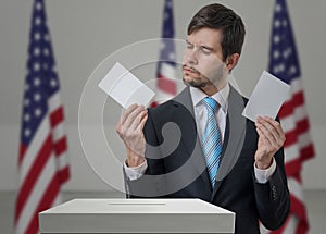 Undecided voter holds envelopes in hands above vote ballot.