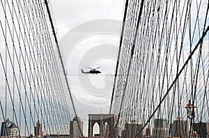 Undefined helicopter flying over Brooklyn Bridge in New York City